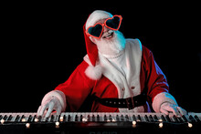 Santa Claus Playing The Electric Piano In A Nightclub At A Christmas And New Year Party Or Corporate Events. Senior Piano Player As Santa At A Concert, Festival, Or Celebration