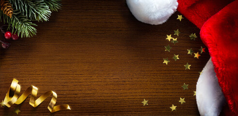 Wall Mural - christmas banner. christmas tree branch and santa hat on wooden background. wide xmas banner mockup,
