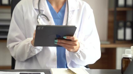 Doctor work on digital tablet healthcare doctor technology tablet using computer in a modern office  in the morning at the desk.
