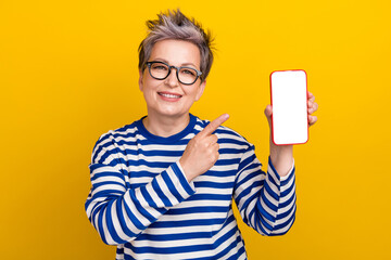 Sticker - Photo of pensioner smiling woman white hair promoter directing smartphone touch screen web menu shop isolated on yellow color background