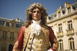 Man with long curly hair dressed like Louis XIV the former french king with 17th century clothing and renaissance castle in background