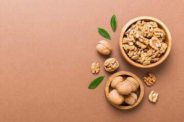 Poster - Walnut kernel halves, in a wooden bowl. Close-up, from above on colored background. Healthy eating Walnut concept. Super foods with copy space