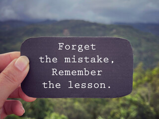 Wall Mural - Motivational and inspirational wording. Forget the mistake, remember the lesson written on a paper. With blurred styled background.