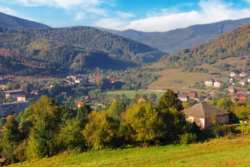 Wall Mural - rural landscape in mountains. remote village in the valley. countryside scenery in autumn. sunny mor