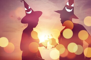 Witch Hat Halloween costume love couple at Sunset: Silhouette Lover Celebrating Outdoors in Costume over candlelight celebrating bokeh effect