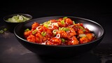 Fototapeta Kuchnia - Delicious Gobi Manchurian Curry. Tasty Indian-Chinese Vegetarian Dish with Fried Cauliflower, Tomatoes, and Onion in Soy Sauce on Black Concrete