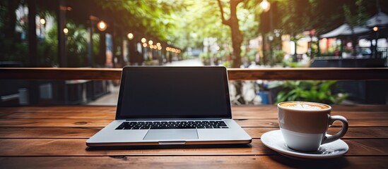 Leinwandbilder - Coffee cup on wooden table in coffee shop with black blank screen workspace