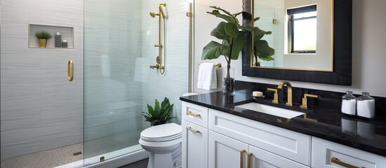 A compact upscale bathroom featuring a black granite countertop white vanity cabinet gold accented shower and sliding glass door