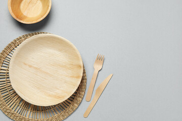 Wall Mural - Wooden plate, bowl and cutlery on light background