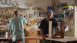 Carpentry shop scene of two carpenters working with tools to build and fix wood furniture