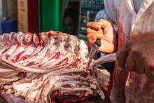Butcher Cutting Up Ribs At An Outdoor Market.