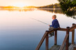 © kieferpix - Boy fishing on a lake at sunset. Location Puget sound Washington state