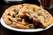 Chocolate chip cookie on a white plate. The cookie is freshly baked and has a gooey center with melted chocolate chip