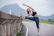 Young athlete sport runner woman under stretching body wraming before run in morning on street is sport healthy concept.