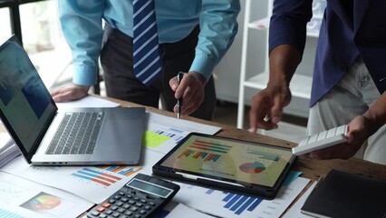 Wall Mural - Teamwork of asian business people discussing and calculating with a calculator on evaluation data in a conference room. with the growth and pointing to the chart graph financial account.