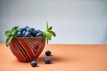 Wall Mural - blueberries in a ceramic bowl on a light background