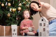 Cute Child With Down Syndrome For Christmas Decorates Christmas Tree With Mom