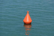 Rot-Orange Boje auf dem Ozean bei ruhigem Meer (nautic sea buoy)
