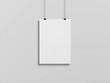 Blank vertical poster hanging with clips on a white wall Mockup. 3D rendering