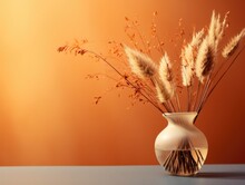 Against The Serene Matte Topaz Canvas, An Artful Arrangement Of Dried Autumn Grasses Stands Gracefully Within A Minimalist Glass Vase, Bathed In A Tender Sidelight That Accentuates Each Detail.