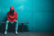 Man wearing hoodie sitting. Banner, light teal and light red colors, emotional sensitivity