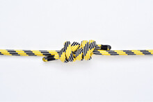 Double Fisherman's Knot On Yellow And Black Nylon Rope On White Background.