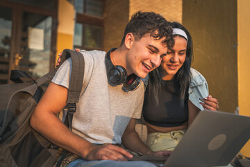 teenage couple students watch video movie on laptop computer at school