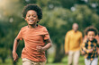 © Charlize Davids/peopleimages.com - Portrait, running and children at a park with parents, freedom and playing in nature together. Love, energy and excited kid face run in a forest with mother, father and bonding, smile and race games