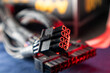 © Kathrine Andi - Cable connectors (8 and 24 pin) from power supply unit of desktop PC close-up. Computer wires hardware components in red color light