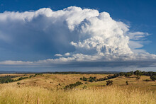 A Dramatic Storm Cloud Building Over A Dry Rural Hillside