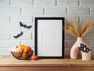 Wall Mural - Poster frame mock up for Halloween holiday. Wheat in modern vase and pumpkin decoration on wooden table over brick wall background