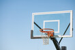 © Austockphoto - Clear glass basketball backboard with rim on blue sky background with copy space