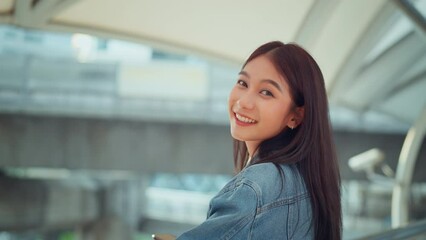Happy young tourist Asian woman smiling looking at camera while stand in the city.
