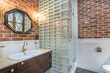 © alhim - Stylish design of the bathroom, decorated with brick tiles. The wall of the shower cabin .is made of glass blocks.