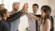 © fizkes - Excited multiracial employees give high five engaged in teambuilding activity in office together, overjoyed young diverse colleagues motivated for shared business win or success, teamwork concept