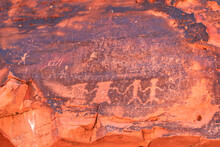 Close Up View Of Native American Rock Art (Petroglyphs) On Red Aztek Sandstone Wall In Petroglyph Canyon Along Mouse Tank Hiking Trail In Valley Of Fire State Park In Mojave Desert, Nevada, USA