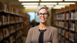 Middle age librarian or college teacher standing in library in front of book shelfes