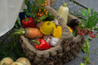peppers, carrots, garlic and other vegetables lie in a wicker basket decorated with cones