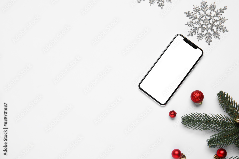 Composition with modern mobile phone and Christmas decorations on white background