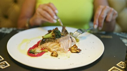 Sticker - Middle age hispanic woman eating fish in a restaurant