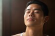 An Asian man in a yoga pose finding inner peace with each breath as an act of selfcare.