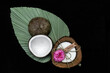 Świeczka ekologiczna zapachowa kokos z różą na zielonym liściu na czarbym tle
