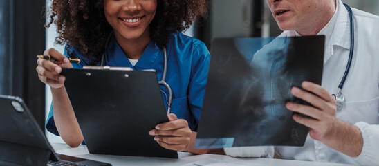 Wall Mural - Medical staff team african american meeting discussing chest x-ray film Radiologists medical doctors that specialize in diagnosing, treating injuries, diseases, radiology, procedures exams, tests