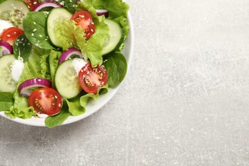 Wall Mural - Delicious salad in bowl on light grey table, top view. Space for text