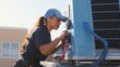 Young woman technician working on air conditioning outdoor unit. Female HVAC worker professional occupation 