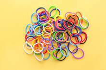 Group Of Colorful Mini Rubber Bands Soft Elastic Bands For Hair On Yellow Background. Elastic Hair Ties, Modern Accessories For Hair,top View