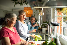 Senior female women preparing a healthy lunch together in the kitchen