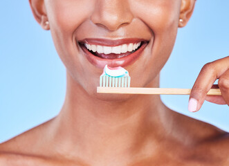 Wall Mural - Closeup, mouth or woman brushing teeth in studio for dental care, fresh breath or healthy smile on blue background. Face of happy model, eco friendly bamboo toothbrush and toothpaste of oral cleaning