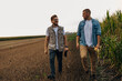 © cherryandbees - Front view of two agronomists walking in the fields.