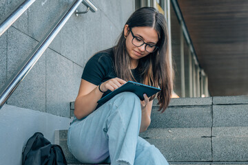 Wall Mural - student teen girl with tablet on the stairs of college or campus